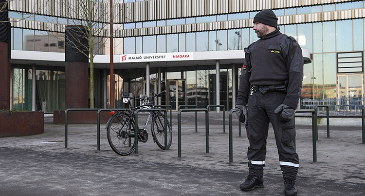 En vakt står utanför en bygnad i glas