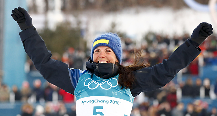 Charlotte Kalla ler och höjer armarna mot luften