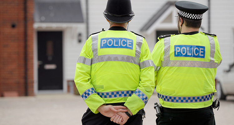 Två brittiska poliser med ryggen mot kameran.