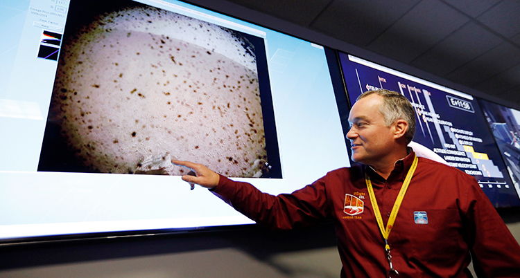 En man från rymdorganisationen Nasa pekar på de första bilderna från Mars.