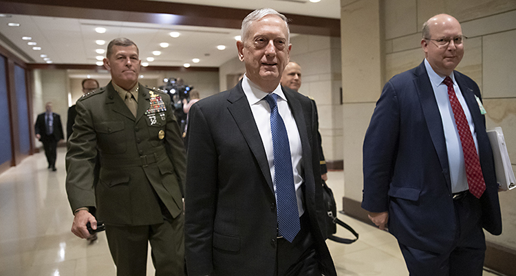 Jim Mattis kommer gående i en korridor tillsammans med några andra personer. Mattis har mörkt blå kostym och lite ljusare blå slips. Han tittar in i kameran.