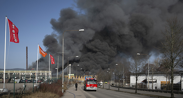 Tjock svart bolmar upp över himlen från det brinnande huset