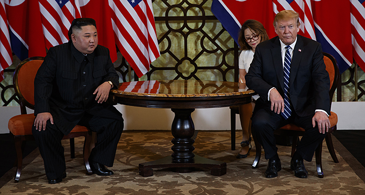 Kim och Trump sitter vid varsitt bord och ser sura ut.
