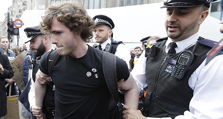 Poliser tar fast en ung demonstrant.
