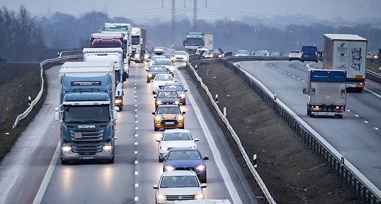 En kö med bilar och lastbilar på motorvägen