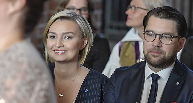 Ebba och Jimmie i fina kläder sitter bredvid varandra och ler