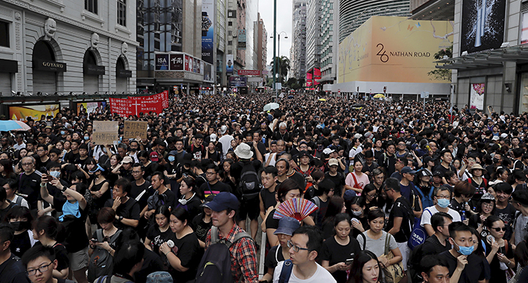 Människor trängs på en bred gata i Hongkong.