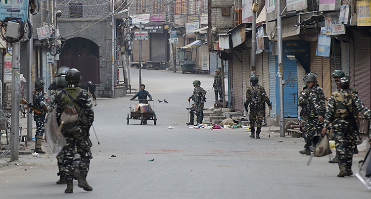 Flera soldater står längs en gata i staden Srinagar i Kashmir.