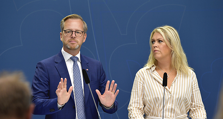 Ministrarna står bredvid varandra. Damberg håler upp händerna och visar handflatorna som ett stopptecken.