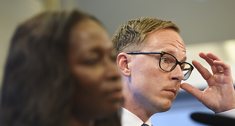 Porträtt på Person som fingrar på sina glasögom. Sabuni sitter bredvid.