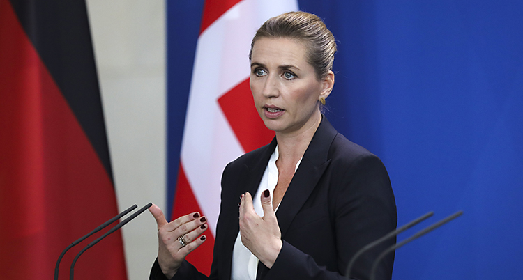Frederiksen ser bestämd ut. håller upp händerna och talar i en mikrofon.