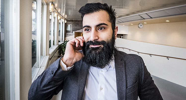 Hanif Bali med en telefon vid örad.