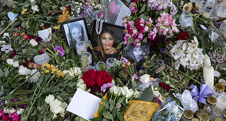 Blommor, fotografier och brev på platsen där en kvinna blev skjuten till döds.