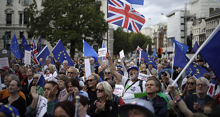 Människor med flaggor från EU och Storbritannien
