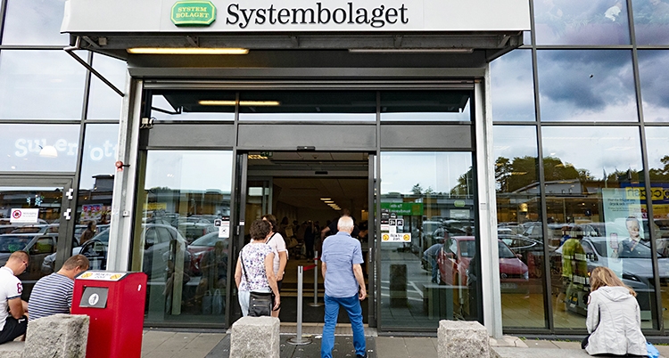 Två personer går in på Systembolaget.