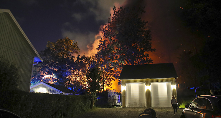 En bild tagen på kvällen. Lågorna syns mot himlen.