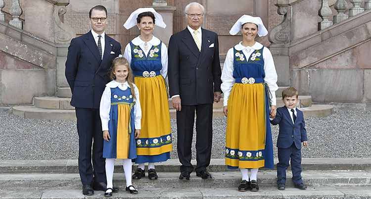 Familjen står utanför slottet i Stockholm. Kvinnorna har nationaldräkt och männen har kostym