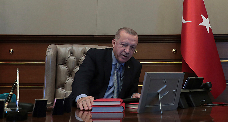 Turkiets president sitter vid ett skrivbord och pratar i telefon.