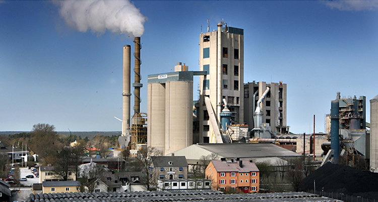 En grå fabrik med skorsten som sprutar ut rök
