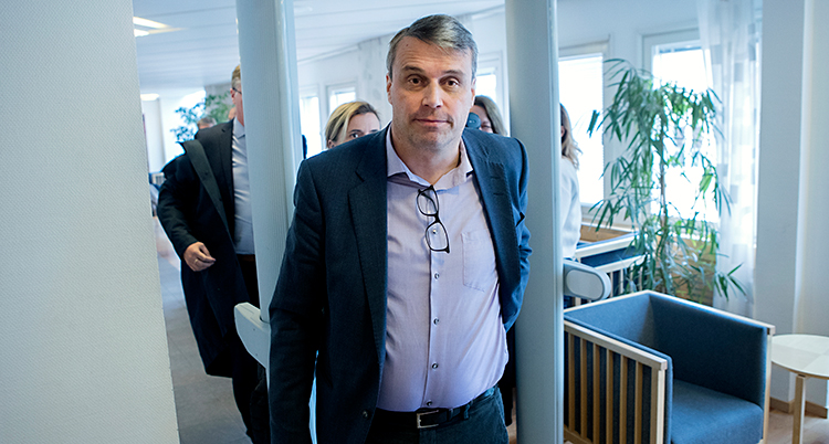 En bild från tingsrätten i Härnösand. Daniel Kindberg har precis gått igenom en larmbåge. Han har på sig en lila skjorta och mörkblå kavaj. I linningen på skjortan hänger ett par glasögon. Han har en sidbena i håret. Mörkt hår med lite stänk av grått i.