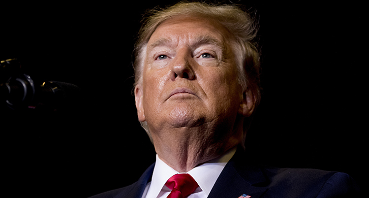 En närbild på USAs president Donald Trump. Han ser stolt ut och sträcker upp hakan. Han har en mörk kavaj, vit skjorta och röd slips.