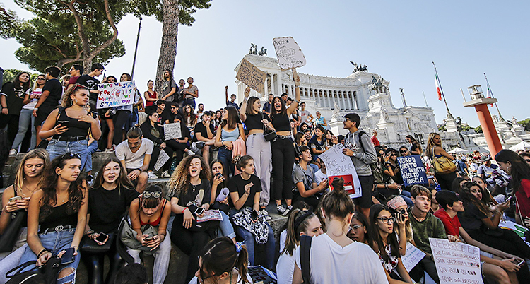 Flera ungdomar demonstrerar i staden Rom i Italien.