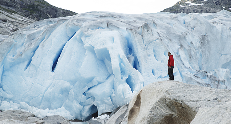 En person står vid en stor norsk glaciär.