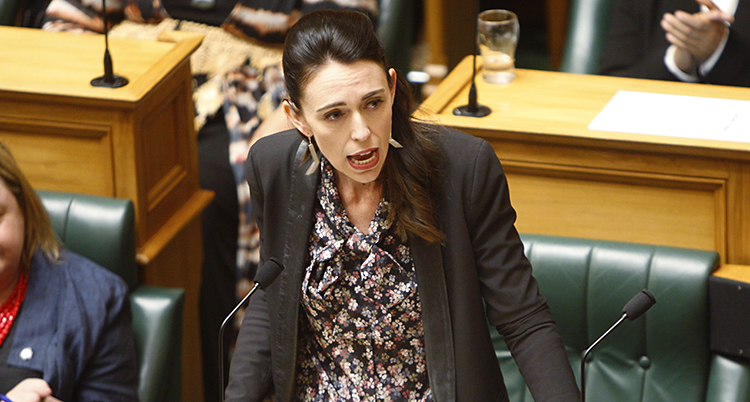 Nya Zeelands ledare Jacinda Ardern pratar om den nya lagen om klimatet. Hon står i riksdagen. Hon har kavaj och en mönstrad skjorta.