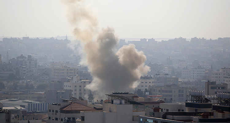 Hustak i staden Gaza City. Ett stort rökmoln stiger mot skyn från staden.