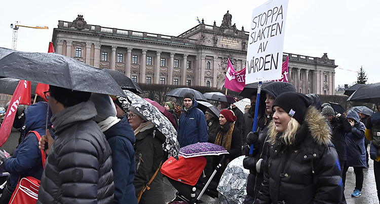 Människor med paraplyer går i tåg