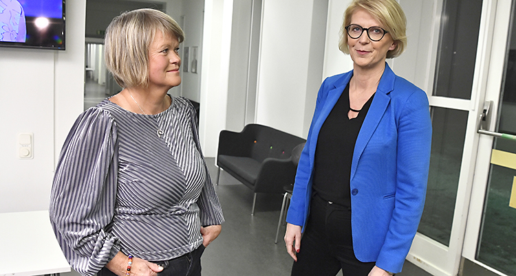 Två kvinnor står bredvid varandra och ser ganska nöjda.