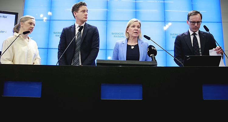 De fyra politikerna står bakom en bord vid varsin mikrofon.