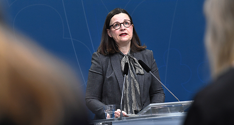 Anna Ekströmer i grått framför en mikrofon.