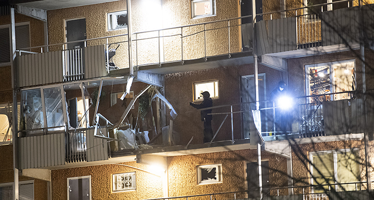 Ett hus med loftgångar på fasaden. Mitt på en av loftgångarna är hela räcket och lägenheten bakom förstörd.