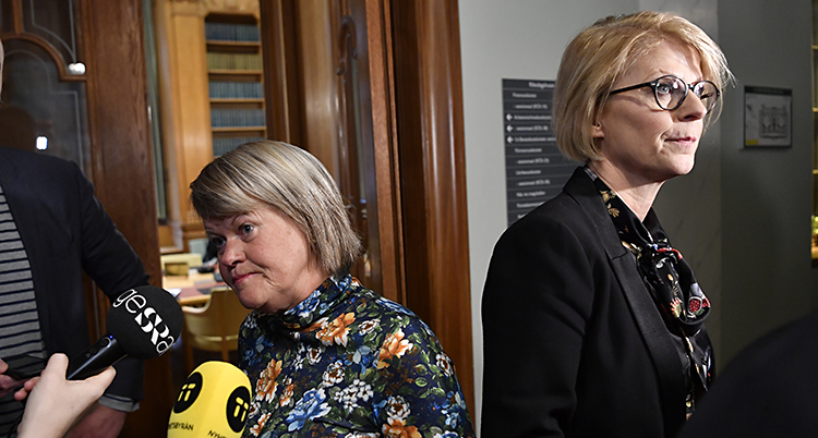 De står rygg mot rygg. Någar mikrofoner hålls fram mot Ulla Andersson.