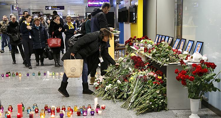 Folk lämnar blommor på flygplatsen i Kiev i Ukraina. Planet i Iran skulle ha landat där.