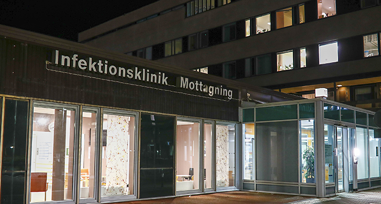 En bild på sjukhuset i Göteborg. Det står infektionsklinik på en stor skylt. Det är kväll på bilden. Det lyser i flera fönster.