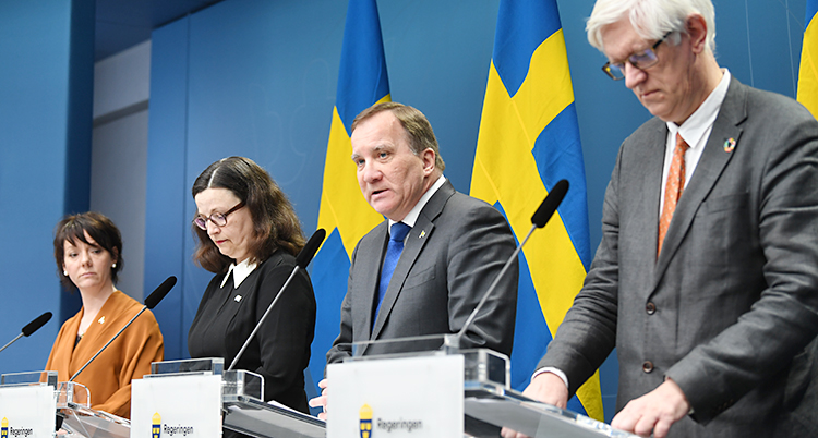 Två kvinnor och två män står framför svenska flaggor och pratar i mikrofon