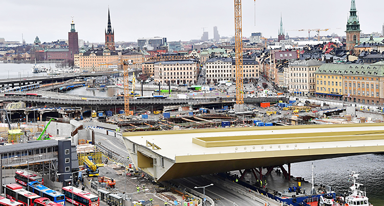 Gamla hus och kyrkor syns bakom den stora guldfärgade bron
