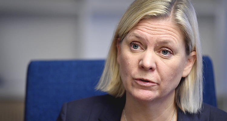 Hon har ljust hår och ser allvarlig ut