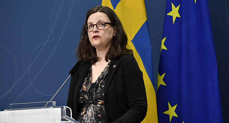 Hon står framför en mikrofon och pratar.