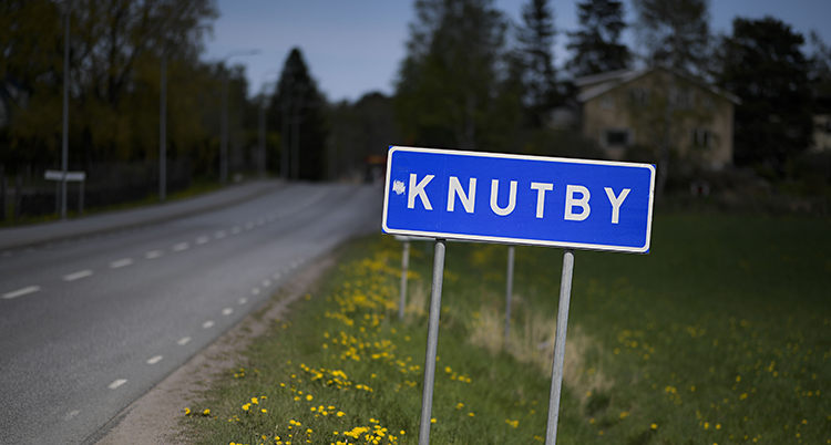 Det är kväll på bilden. En vägskylt syns i mörkret.