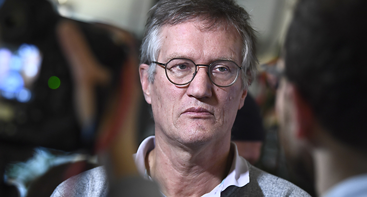 En närbild på en man. Han ser allvarlig ut.
