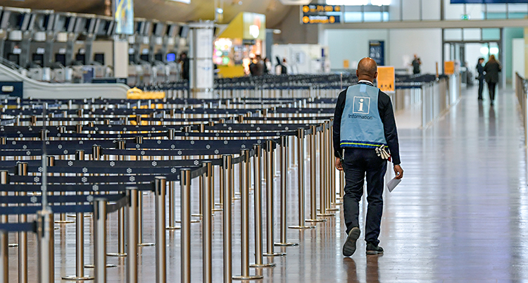 En ensam man går i en stor hall på flygplatsen.