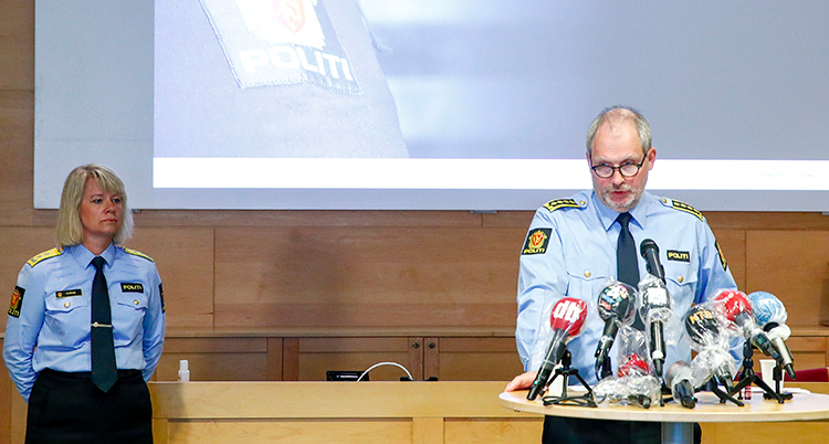 Två poliser står på en scen och pratar i mikrofon