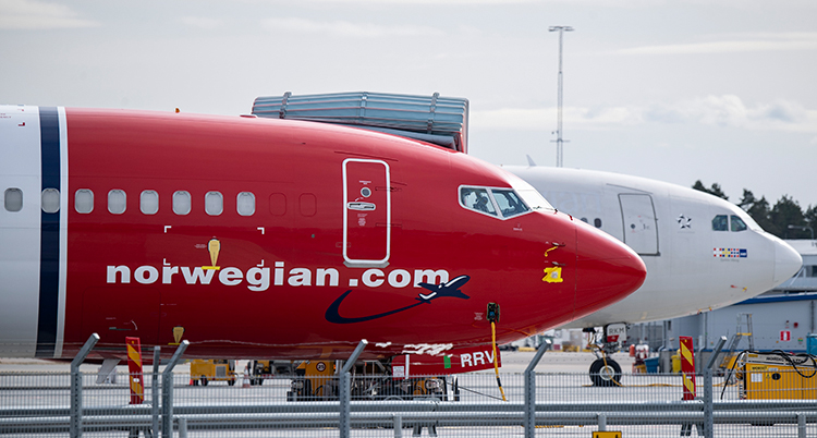 Ett rött plan står parkerat på marken.