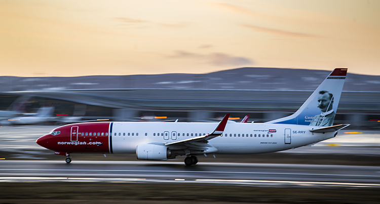 Ett plan som det står Norwegian på tar sats. Det är på väg att lyfta. Det åker fort.