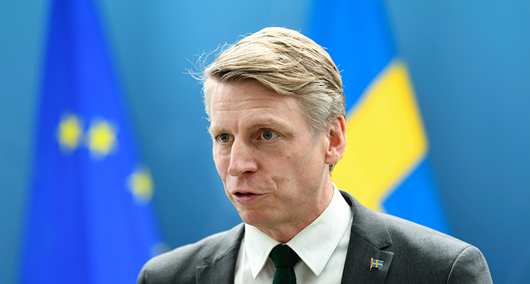 Han har svart slips och vit skjorta.