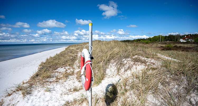 En sandstrand med blå himmel och hav