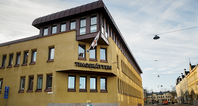En bild på tingsrätten. Det är ett gult hus.